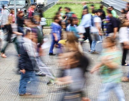 Blurred photo of people walking in busy street